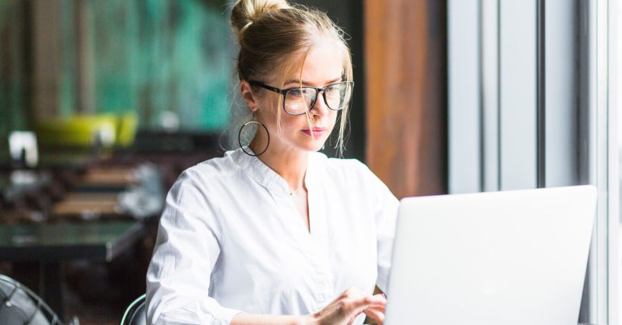A person with glasses reading a document in a laptop